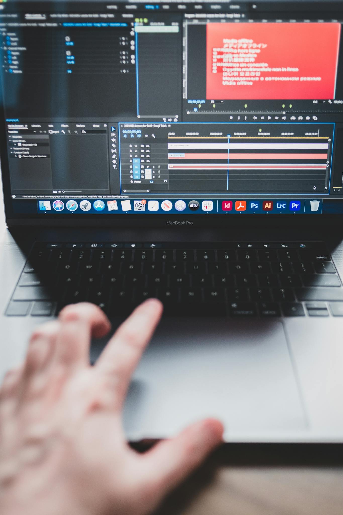 A person works on video editing software on a laptop, focusing on the screen.