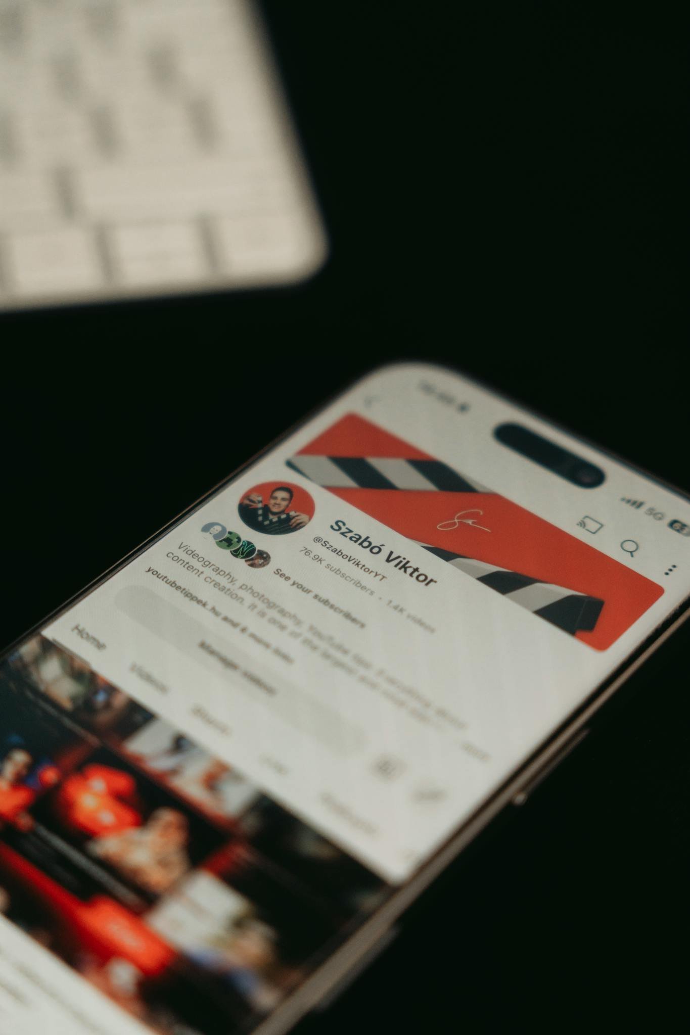 A smartphone showing a YouTube channel page screenshot in focus with blurred background.